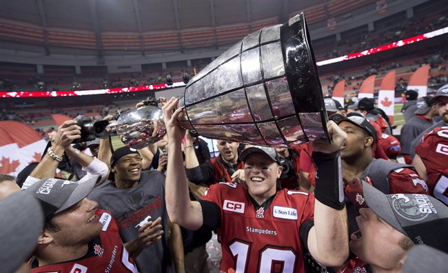 Calgary Stampeders quarterback Bo Levi Mitchell hoists the Grey Cup as he celebrates his teams win against the Hamilton Tiger-Cats during the 102nd Grey Cup in Vancouver, B.C. Sunday, Nov. 30, 2014. The Stampeders have locked up starting quarterback Mitchell through the 2018 season.