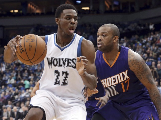 Minnesota Timberwolves' Andrew Wiggins, left, drives around Phoenix Suns' P.J. Tucker during the second half of an NBA basketball game, Friday, Feb. 20, 2015, in Minneapolis.