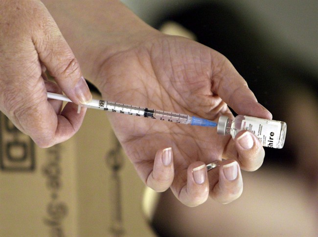 A nurse loads a syringe with vaccine for injection in Victoria, Saturday, Oct. 23, 2004. 