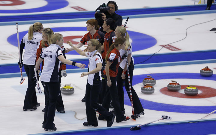 Switzerland's Nicole Schwaegli, front left, and Marisa Winkelhausen, front right, celebrate after winning their final match against Canada at the World Women's Curling Championship in Sapporo.