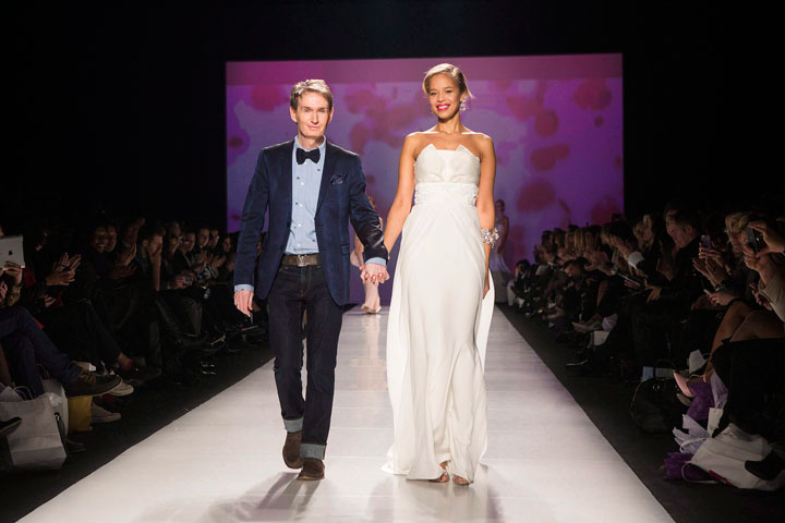 David Dixon (left) takes the applause as he accompanies model showing one of his creations during Toronto Fashion Week in Toronto on Tuesday March 18, 2014. Dixon is preparing to mark a key milestone at Toronto's World MasterCard Fashion Week on Tuesday with the launch of his latest collection as he celebrates the 20th anniversary of his label.