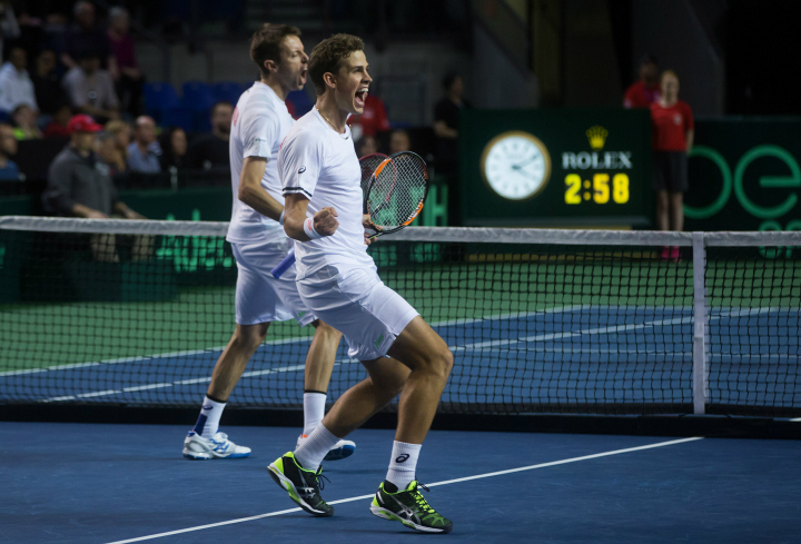 Canada's Vasek Pospisil, of Vancouver, B.C., and Daniel Nestor, back, of Toronto, Ont., celebrate after defeating Japan's Go Soeda and Yasutaka Uchiyama in five sets during a Davis Cup tennis world group first round doubles match in Vancouver, B.C., on Saturday March 7, 2015. 