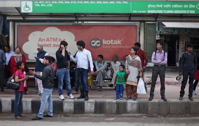 Indians wait for a bus at the bus stop where the victim of a deadly gang rape boarded on Dec. 16, 2012, in New Delhi, India, Wednesday, March 4, 2015.