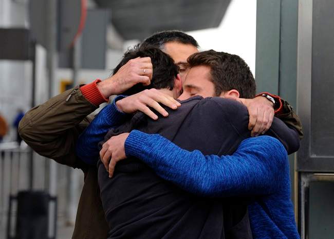 People comfort each other as they arrive at the Barcelona airport in Spain, Tuesday, March 24, 2015.