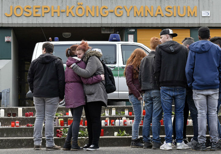 Two girls hug as they cry beside candles and flowers placed in front of the Joseph-Koenig-Gymnasium in Haltern, western Germany Tuesday, March 24, 2015. There were 16 students and 2 teachers from Haltern among the 150 people on board.