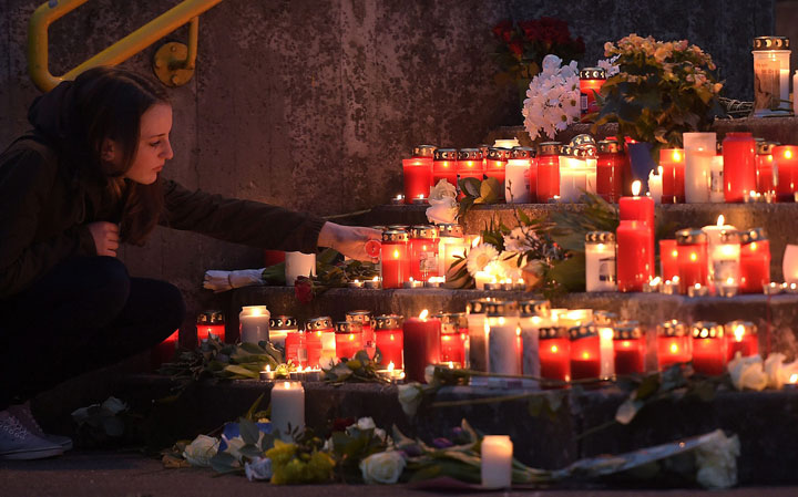 A student lights a candle in front of the Joseph-Koenig Gymnasium in Haltern, western Germany Tuesday, March 24, 2015. 