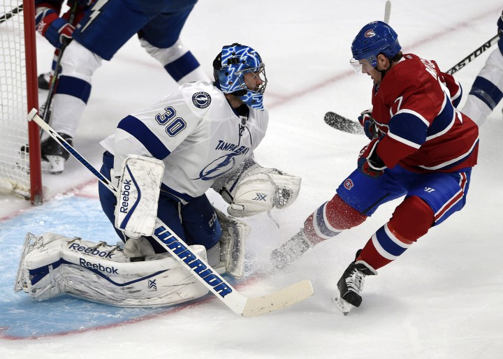 Tampa Bay Lightning goalie Ben Bishop (30) stops Montreal Canadiens center Torrey Mitchell (17) during third period National Hockey League action Tuesday, March 10, 2015 in Montreal.