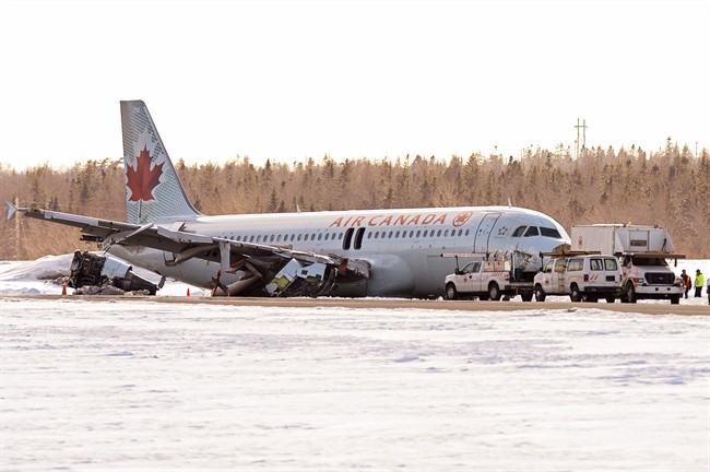 Investigators stand near Air Canada flight AC624 at Halifax Stanfield International Airport in Halifax, hours after the plane crashed, on Sunday, March 29, 2015. On Tuesday, Dec. 13, Transport Canada failed at removing itself as a defendant in a class action lawsuit filed on behalf of the 133 passengers of AC 624.