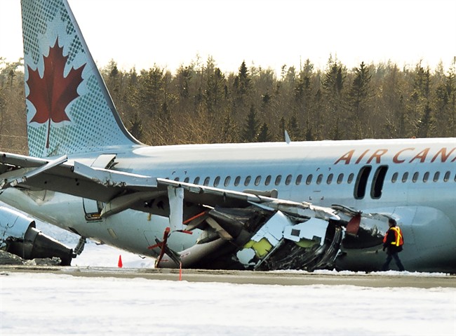 An investigator inspects Air Canada flight AC624 that crashed early Sunday morning during a snowstorm, at Stanfield International Airport in Halifax on Sunday, March 29, 2015.
