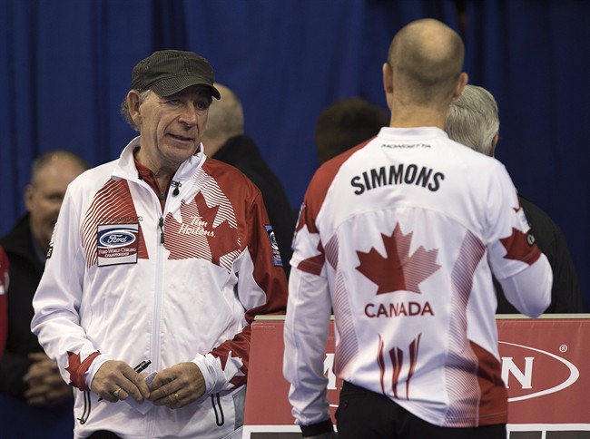 Team Canada coach Earle Morris, left, chats with skip Pat Simmons during a break in play against Russia at the men's world curling championships in Halifax on Monday, March. 30, 2015.
