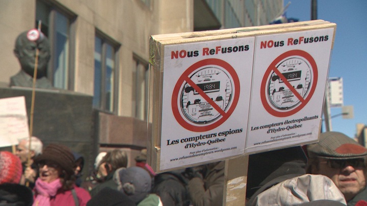 Protesters carry signs showing their opposition to Hydro-Quebec’s planned fee hikes and smart meters. March 28, 2015.