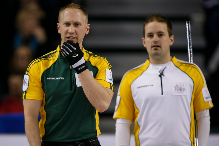 Northern Ontario skip Brad Jacobs, left, ponders a shot as Manitoba skip Reid Carruthers looks on during curling action at the Brier in Calgary, Tuesday, March 3, 2015.