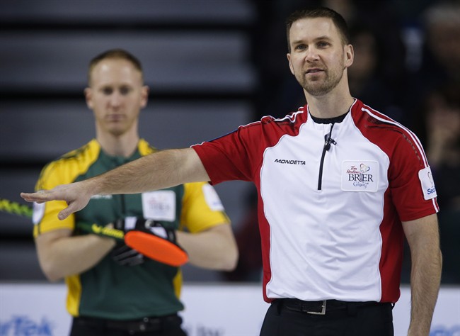 Newfoundland and Labrador skip Brad Gushue, right, gestures to his teammates as Northern Ontario skip Brad Jacobs looks on during curling action at the Brier.