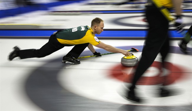 Northern Ontario skip Brad Jacobs, left, launches a rock as his team plays New Brunswick during curling action at the Brier.