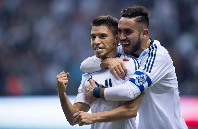 Vancouver Whitecaps FC's Nicolas Mezquida, left, celebrates his goal with teammate Pedro Morales against the Portland Timbers during the first half of MLS soccer action in Vancouver, B.C. Saturday, March 28, 2015. THE CANADIAN PRESS.