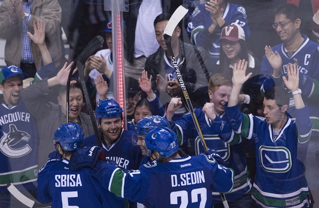Vancouver Canucks right wing Zack Kassian (9) celebrates his goal with teammates Luca Sbisa (5) Daniel Sedin (22) and Dan Hamhuis during the third period of NHL action against Anaheim Ducks in Vancouver, B.C. Monday, March 9, 2015. 