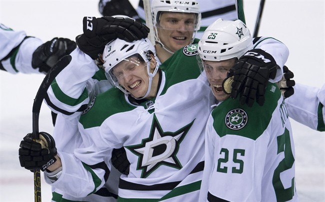 Dallas Stars John Klingberg (3) celebrates his game-winning goal with teammate Brett Ritchie (25) during the overtime period of NHL action against the Vancouver Canucks in Vancouver, B.C. Saturday, March. 28, 2015.