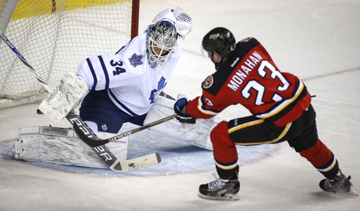 Toronto Maple Leafs goalie James Reimer, left, lets in a goal by Calgary Flames Sean Monahan during first period NHL hockey action in Calgary, Friday, March 13, 2015.