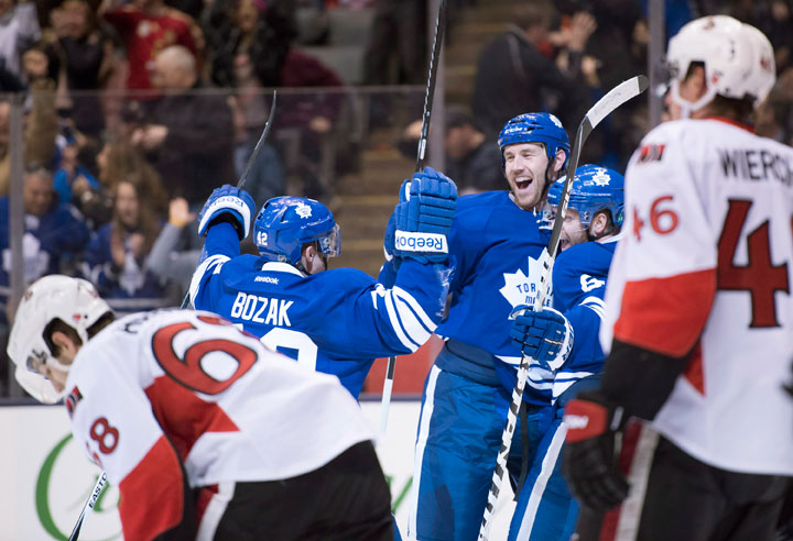 Toronto Maple Leafs defenceman Eric Brewer is congratulated by teammates Tyler Bozak and Phil Kessel on his game-winning overtime goal as Ottawa Senators Patrick Wiercioch and Mike Hoffman react during NHL action in Toronto on Saturday, March 28, 2015.