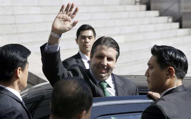 U.S. Ambassador to South Korea Mark Lippert, surrounded by security men, waves as he leaves Seoul's Severance Hospital in Seoul, South Korea Tuesday, March 10, 2015. Lippert was released Tuesday after five days in the hospital for treatment of injuries caused by a knife attack. A man slashed him on the face and left arm during a breakfast forum in Seoul. (AP Photo/Lee Jin-man).