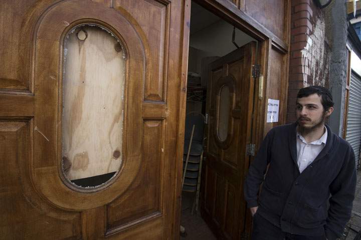A Jewish man surveys a damaged door outside the Ahavas Torah synagogue in the Stamford Hill area of north London on March 22, 2015.