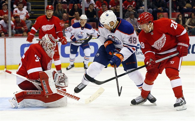 Detroit Red Wings goalie Jimmy Howard (35) stops a shot as defenseman Marek Zidlicky (28) defends against Edmonton Oilers Ryan Hamilton (48) in the third period of an NHL hockey game in Detroit Monday, March 9, 2015. 