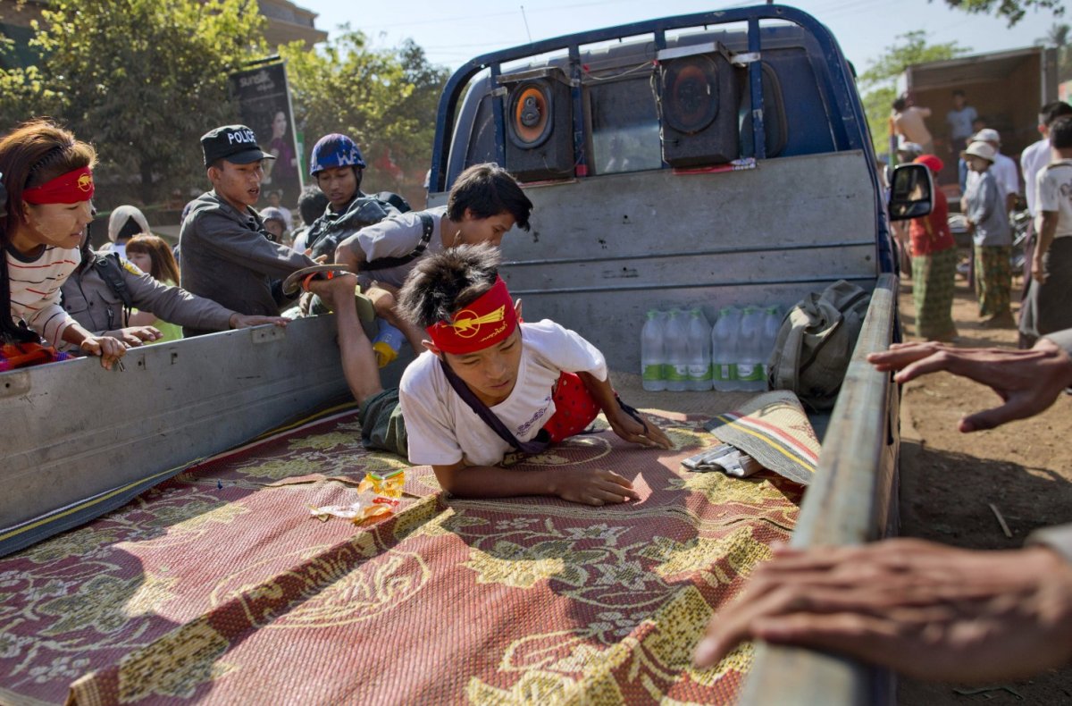 A student protester lies on the back of a truck while two other students are pushed by police officers onto the vehicle in Letpadan, north of Yangon, Myanmar Friday, March 6, 2015. Police cracked down on student protesters opposing Myanmar's new education law Friday, roughly grabbing demonstrators and loading them onto trucks in the third such clampdown in as many days.
