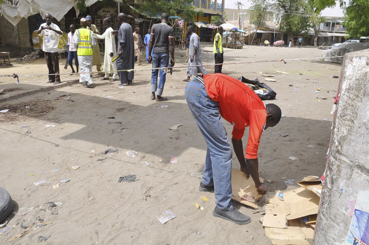 People gather at the site of a bomb explosion at a market in Maiduguri, Nigeria, Saturday, March 7, 2015.