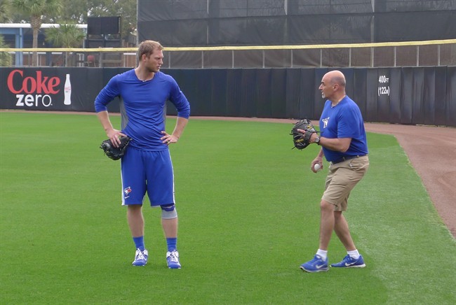 Blue Jays outfielder Michael Saunders chats with head trainer George Poulis after a throwing session in Dunedin, Fla., on Friday, March 6, 2015. 