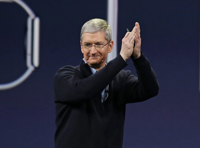 In this Monday, March 9, 2015 photo, Apple CEO Tim Cook applauds at the conclusion of the Apple "Spring Forward" launch event in San Francisco. Cook took a figurative victory lap at his company’s annual shareholder meeting Tuesday, one day after he announced details about the new smartwatch Apple plans to sell next month.