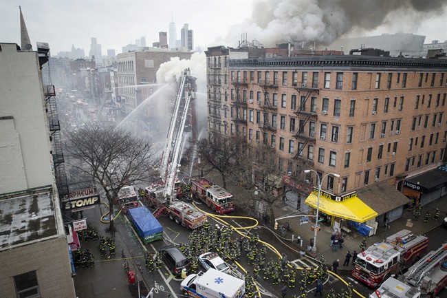 New York City firefighters work the scene of a large fire and a partial building collapse in the East Village neighborhood of New York on Thursday, March 26, 2015. At least two people remain missing.