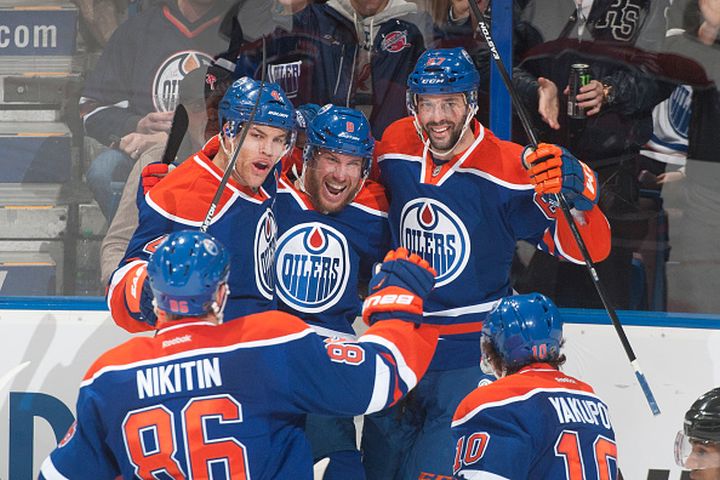 Taylor Hall #4, Derek Roy #8 and Benoit Pouliot #67 of the Edmonton Oilers celebrate after a goal during the game against the Colorado Avalanche on March 25, 2015 at Rexall Place in Edmonton, Alberta, Canada.