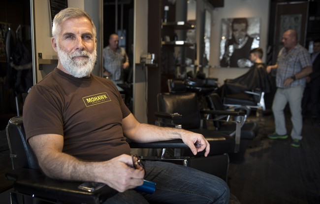 Jean-Marc Cardinal is seen in his barber shop Wednesday, March 4, 2015 in Montreal. Cardinal has owned and operated his barber shop, Mohawk Barbier Montreal, for 13 years, and said "for sure business is going down in the village." .