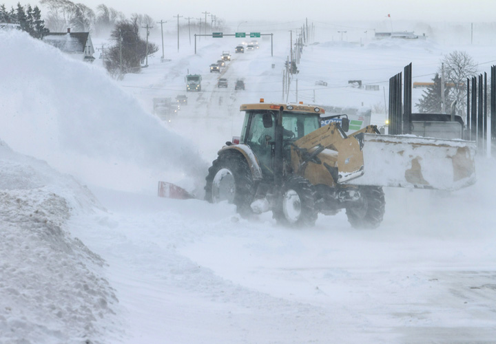 A farmer works to clear the Trans Canada Highway near Cherry Valley, P.E.I., on Monday, March 23, 2015.