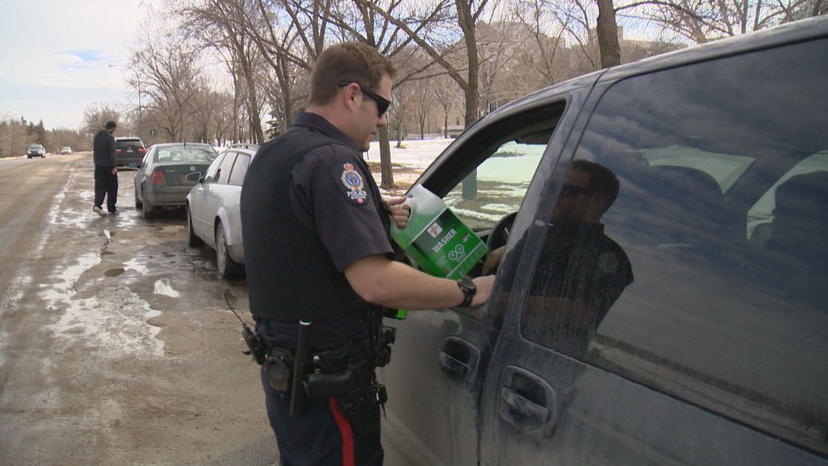 Const. Curtis Warnar gave a jug of windshield washer fluid to a motorist Friday morning.
