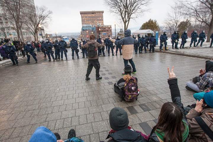 Protesters and police stand their ground during a protest against austerity organized by the ASSE student group in Quebec City, Thursday, March 26, 2015.