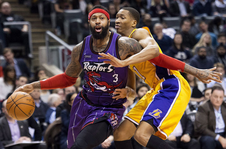 Toronto Raptors forward James Johnson drives past Los Angeles Lakers' Wesley Johnson, right, during first half NBA basketball action in Toronto on Friday, Mar. 27, 2015. 
