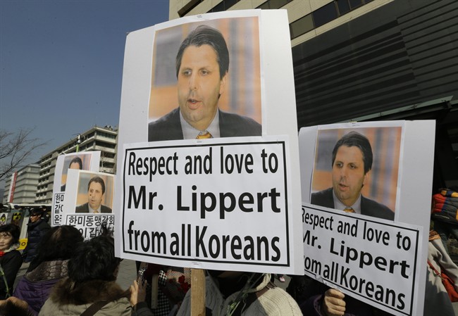South Korean conservative activists hold portraits of U.S. Ambassador to South Korea Mark Lippert during a rally demanding his quick recovery near the U.S. embassy in Seoul, South Korea, Friday, March 6, 2015. A knife attack on Thursday that injured Lippert is the latest act of political violence in a deeply divided country where some protesters portray their causes as matters of life and death. 