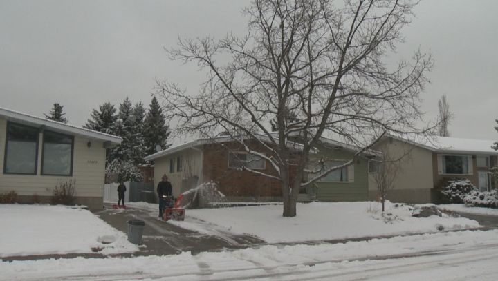 Edmontonians clear their driveways after snowfall Friday, March 20, 2015.