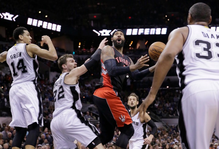 Toronto Raptors’ James Johnson, center, looks to shoots as he is surrounded by San Antonio Spurs’ Danny Green (14), Tiago Splitter (22), Boris Diaw (33) and Marco Belinelli, second from right, during the first half of an NBA basketball game, Tuesday, March 10, 2015, in San Antonio.
