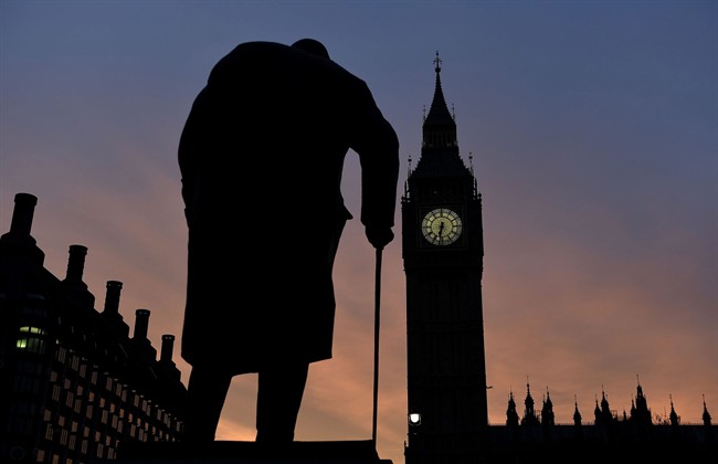 The sun rises behind the Palace of Westminster and the statue of Sir Winston Churchill in central London Monday March 30, 2015. Campaigning formally began Monday in the most unpredictable U.K. election in decades.