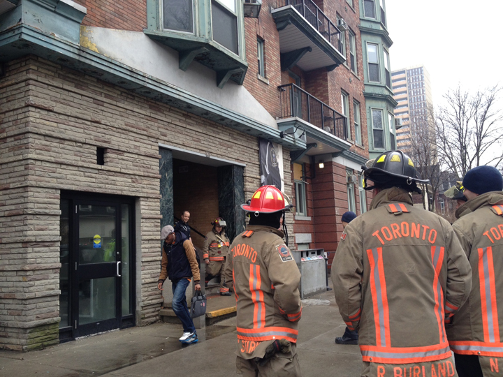 Toronto firefighters stand outside of 21 Sussex Ave. where white powder was found inside an envelope.