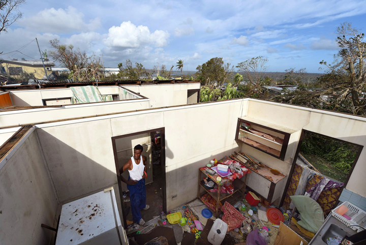 Uwen Garae surveys his damaged house in Port Vila, Vanuatu in the aftermath of Cyclone Pam Monday, March 16, 2015. 