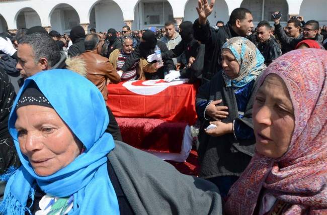 Tunisian people attend the funerals of elite security member Aymen Morjen, Thursday March 19, 2015 in Tunis. Morjen was killed in the Wednesday attack at the Bardo National museum. The Islamic State group issued a statement Thursday claiming responsibility for the deadly attack on Tunisia's national museum that killed 23 people, mostly tourists.