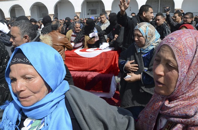 Tunisian people attend the funerals of elite security member Aymen Morjen, Thursday March 19, 2015 in Tunis. Morjen was killed in the Wednesday attack at the Bardo National museum. The Islamic State group issued a statement Thursday claiming responsibility for the deadly attack on Tunisia's national museum that killed 23 people, mostly tourists.