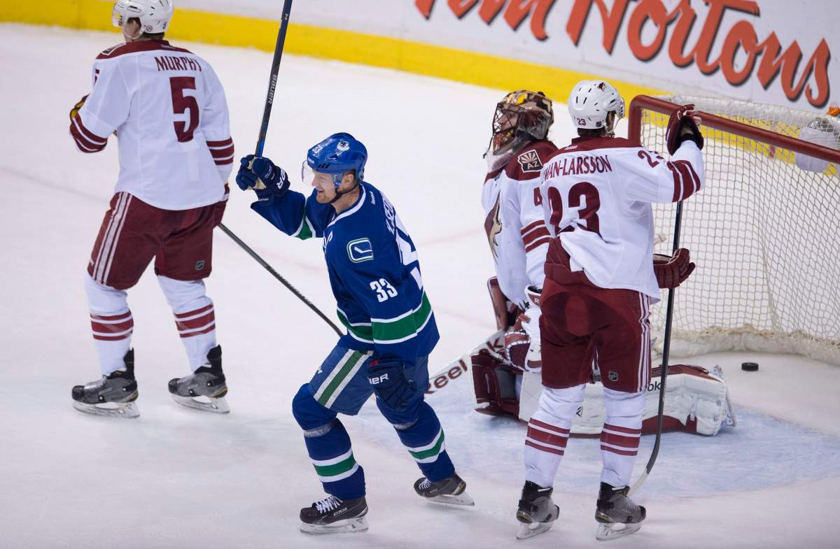 Vancouver Canucks center Henrik Sedin celebrates teammate Yannick Weber's goal  during the second period. 