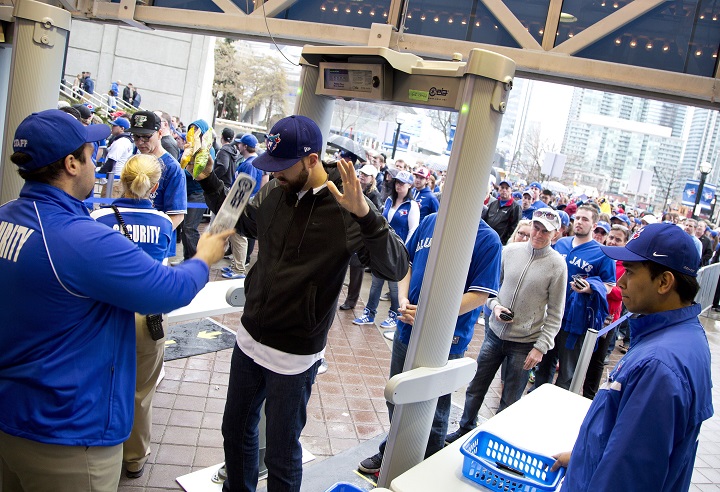 Fans go through the new MLB mandatory security screening before the Toronto Blue Jays play against the Tampa Bay Rays during the home opener in Toronto on Monday, April 13, 2015.