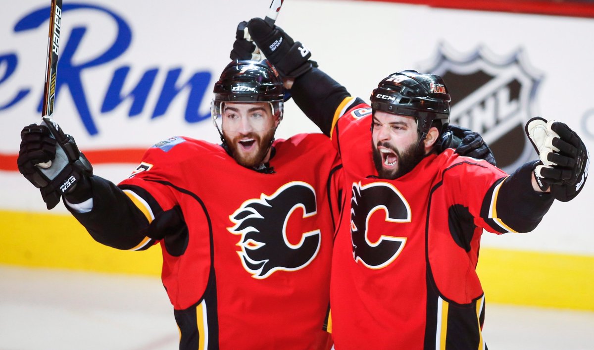 Calgary Flames Brandon Bollig, right, celebrates his goal with teammates TJ Brodie during first period NHL first round playoff hockey action against the Vancouver Canucks in Calgary, Sunday, April 19, 2015.