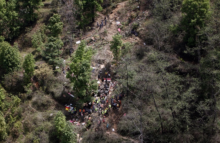 Nepalese rescue workers look for survivors in the wreckage of a bus after an accident, about 16 kilometers (10 miles) west of Kathmandu, Nepal, Wednesday, April 22, 2015. The bus, carrying Hindu pilgrims from the Indian state of Gujrat on a visit to the Pashupatinath temple, plunged off a mountain highway near Nepals capital on Wednesday. 