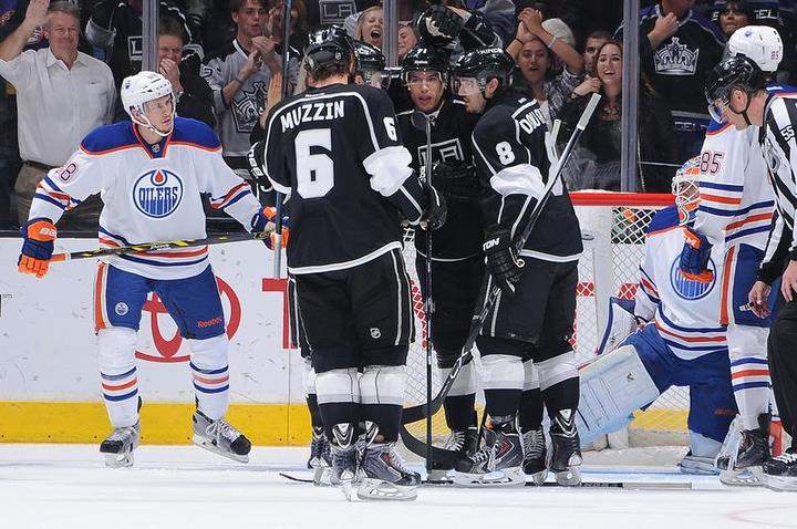 Jake Muzzin #6, Jordan Nolan #71, and Drew Doughty #8 of the Los Angeles Kings celebrate during a game against the Edmonton Oilers at STAPLES Center on April 02, 2015 in Los Angeles, California. 
